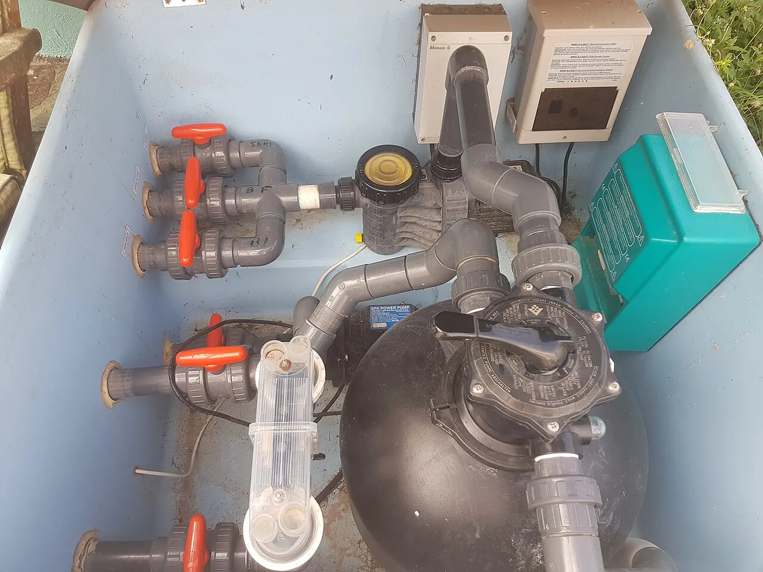 Pool pump, filter, valves and pipework in an outdoor equipment enclosure