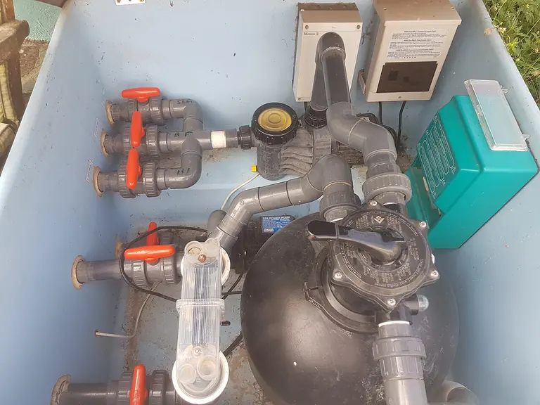 Wide view showing a pool pump, filter, valves and connected pipework
